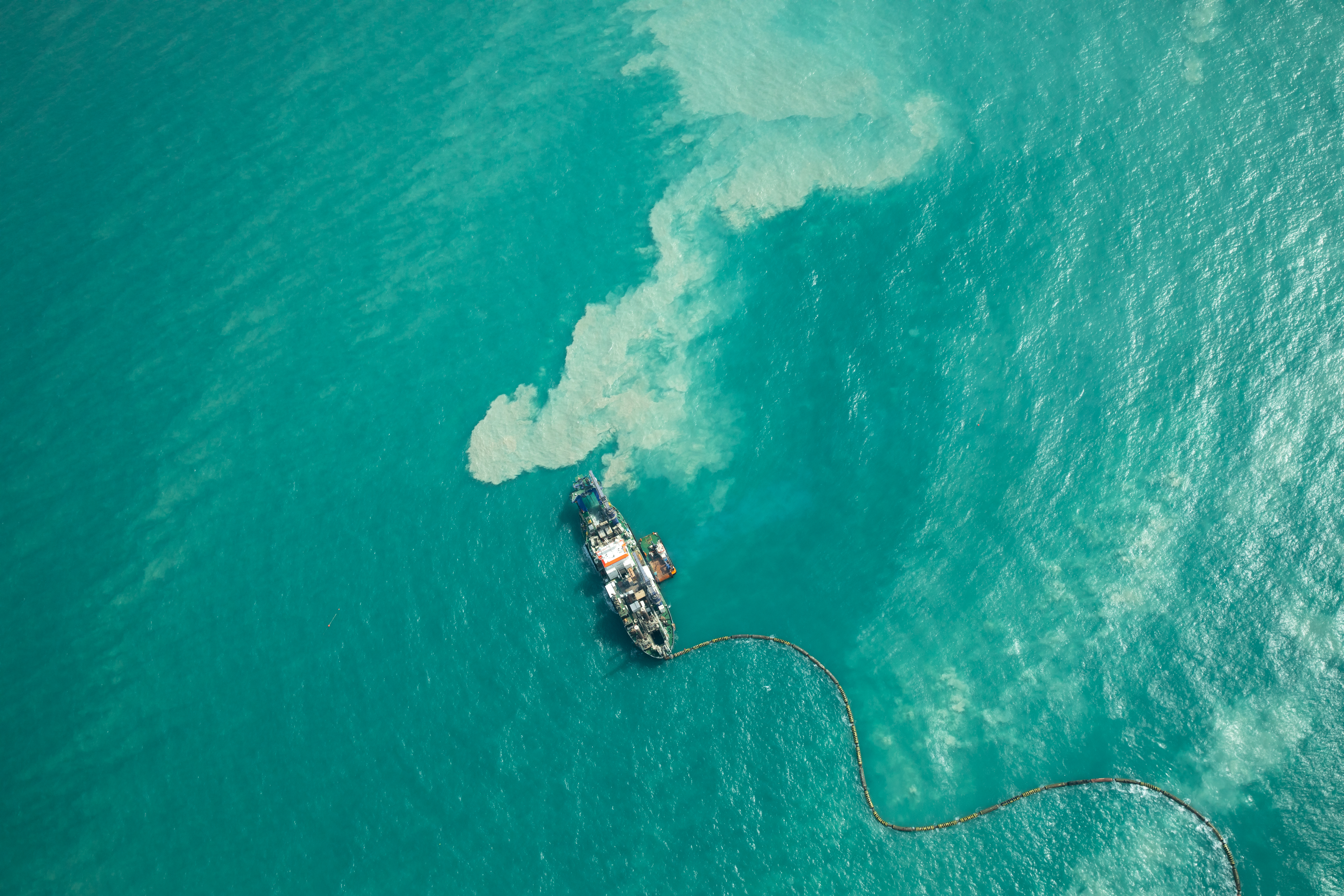 Aerial view of dredging vessel in turquoise waters